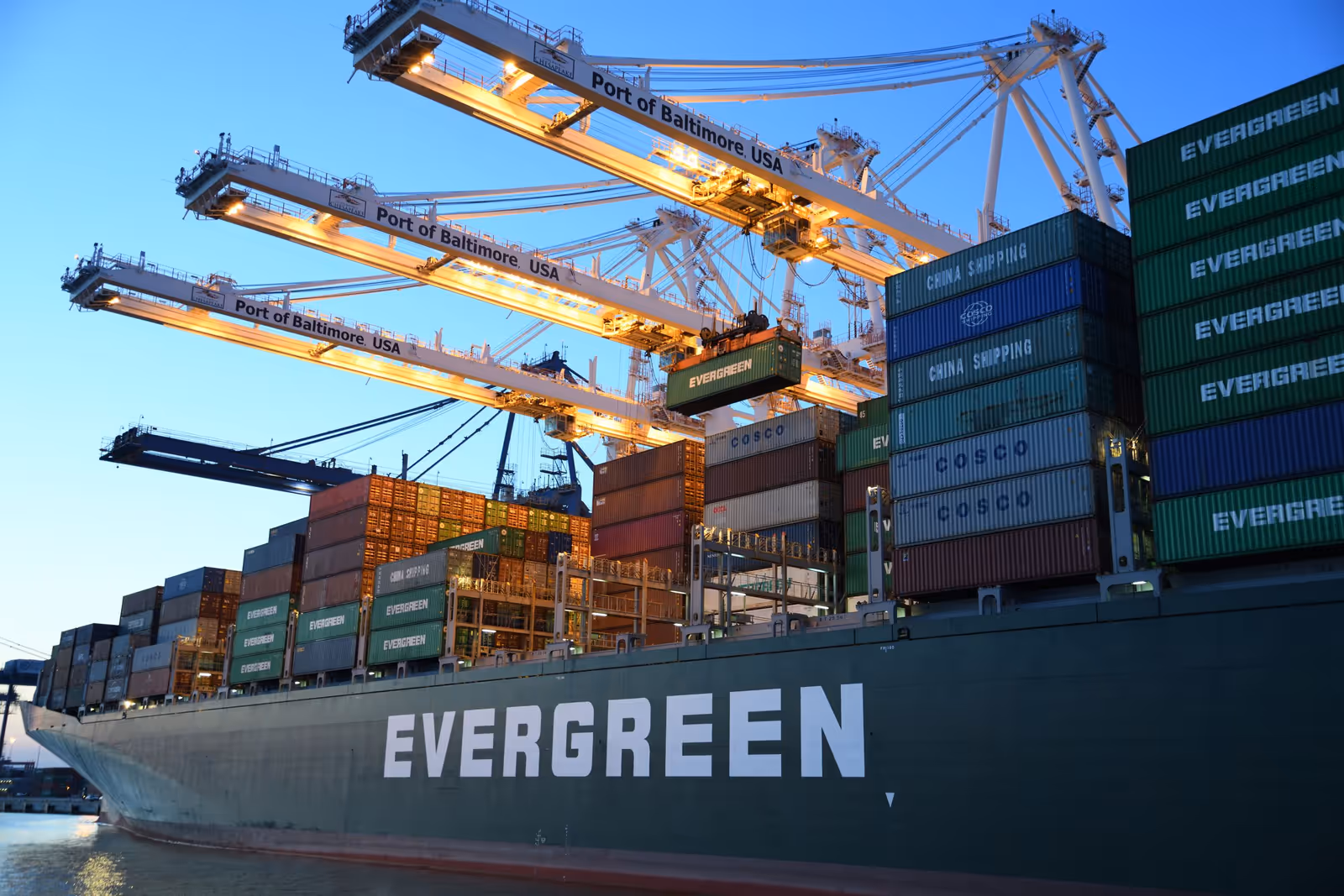 Container ship docked beneath port cranes